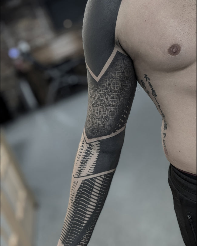 bioorganic industrial sleeve tattoo – heavy blackwork abstraction inspired by ancient Egyptian art