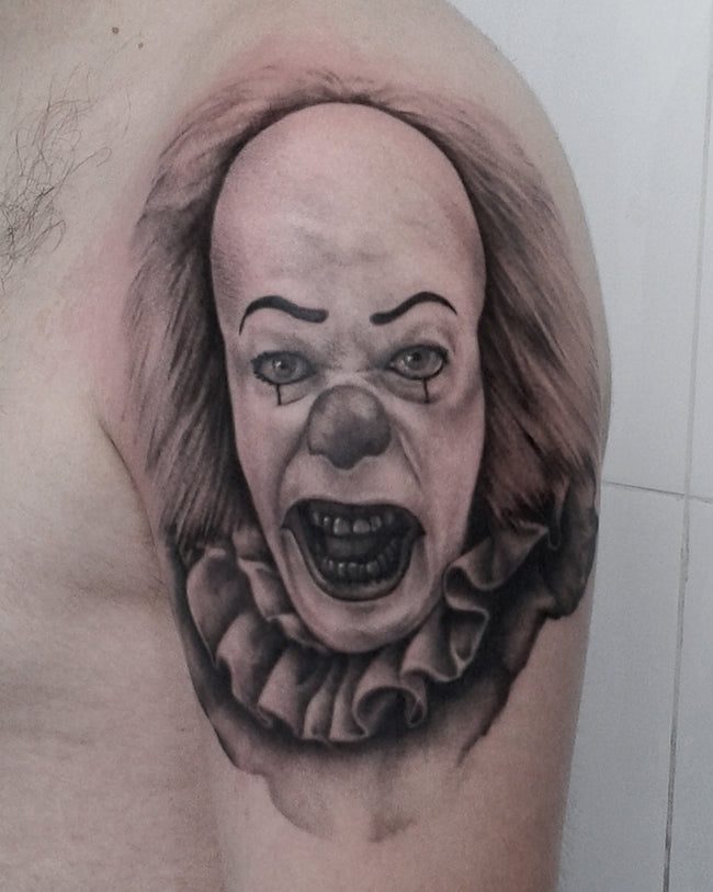 hyperrealistic Pennywise portrait tattoo – black and grey shoulder piece