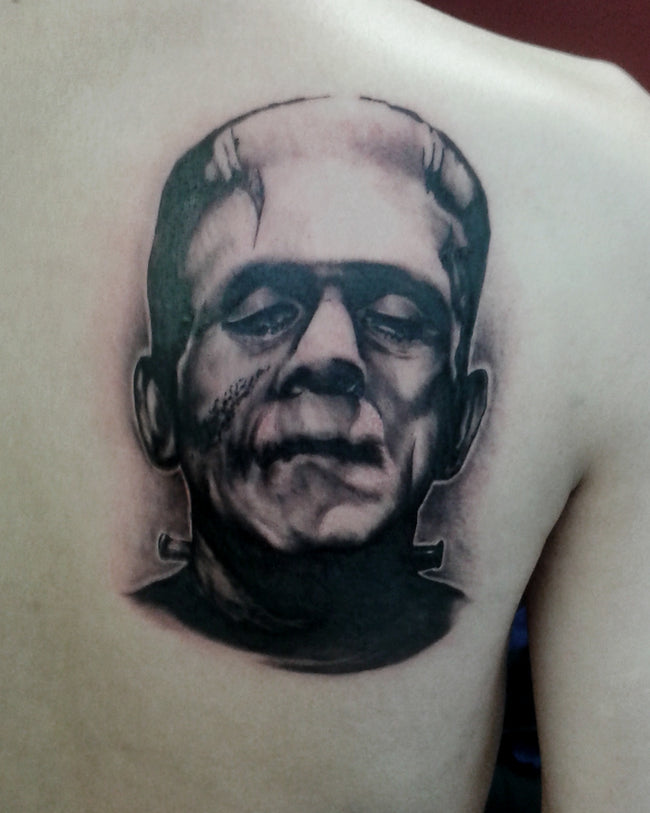 hyperrealistic Frankenstein portrait tattoo – black and grey shoulder blade/back piece