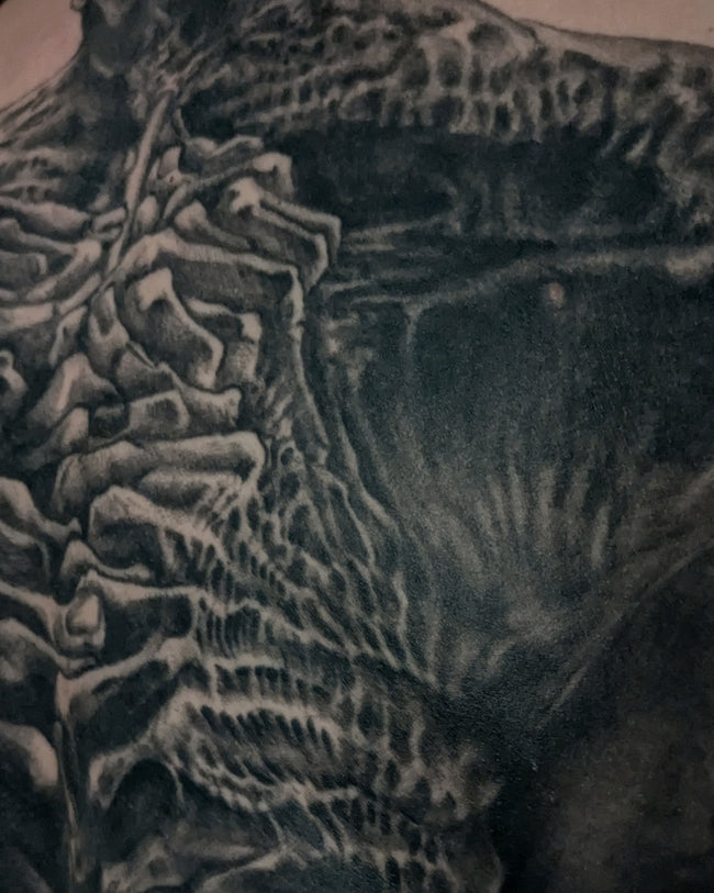 Beksinski-inspired tattoo detail – black and grey musician figure closeup, full back piece