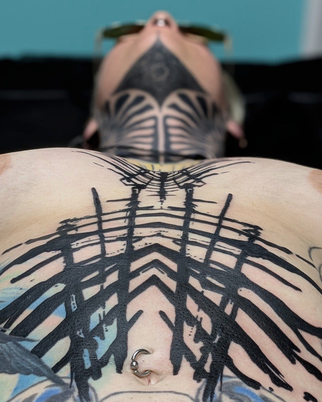 bioorganic industrial abstraction tattoo – solid black pattern across belly, belly detail closeup