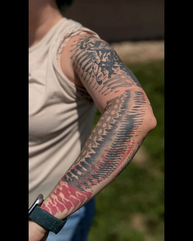 bioorganic industrial sleeve tattoo – black, gray and red industrial pattern with realistic cat skull, detail