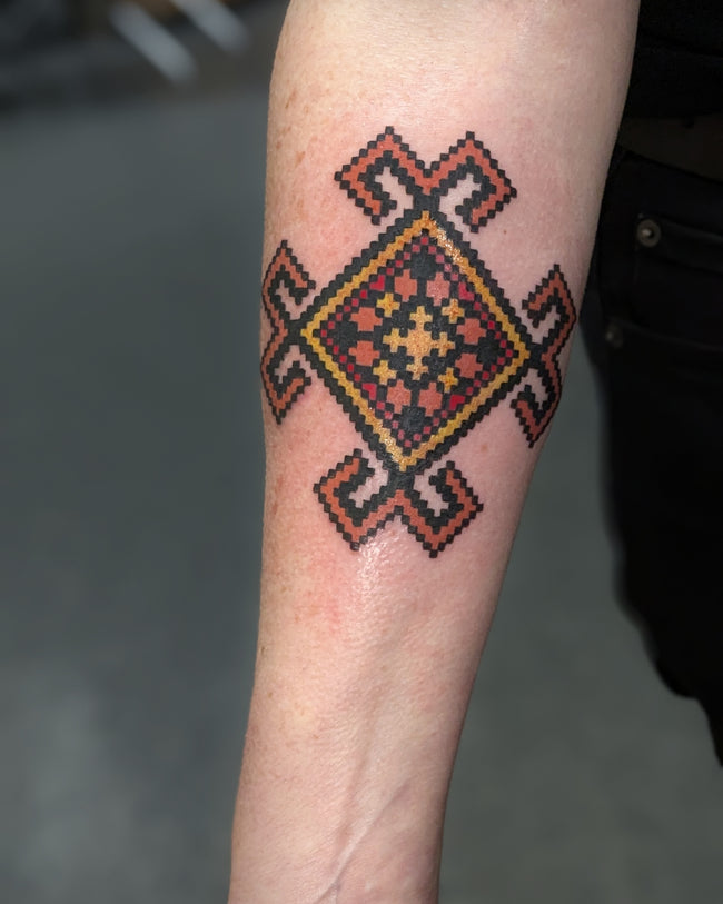 Polish folk ornament tattoo – full color embroidery inspired design on forearm
