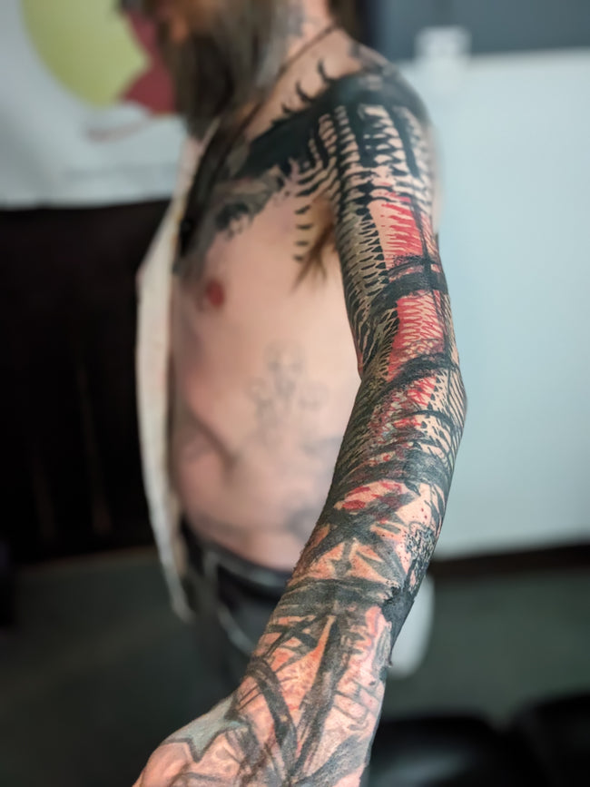 bioorganic industrial blast-over sleeve – heavy black and red patterns, detailed closeup