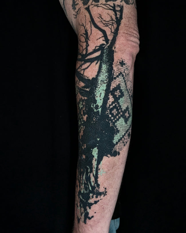 bioorganic industrial tree tattoo – heavy black with ink splash and folk embroidery pattern, teal color detail