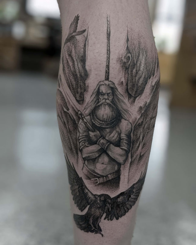 illustrative leg tattoo – Odin hanging from Yggdrasil, pierced by spear Gungnir with ravens Huginn and Muninn